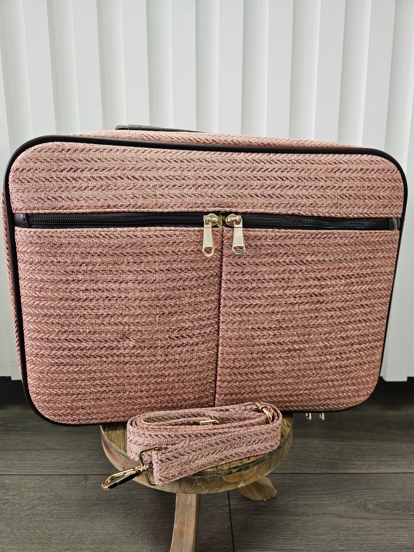 Pink suitcase bag with shoulder strap.