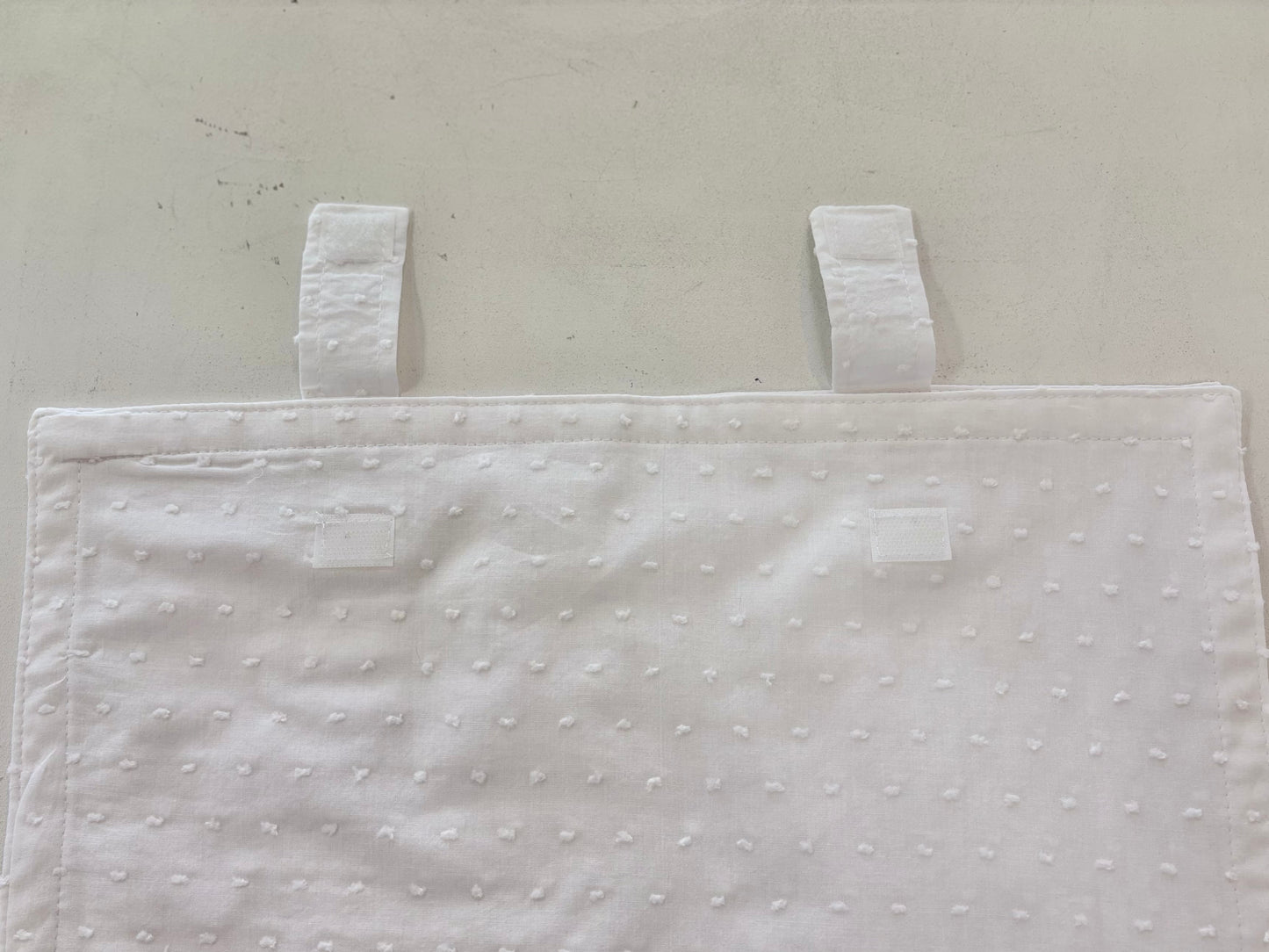White cotton envelope with Velcro strap closure.