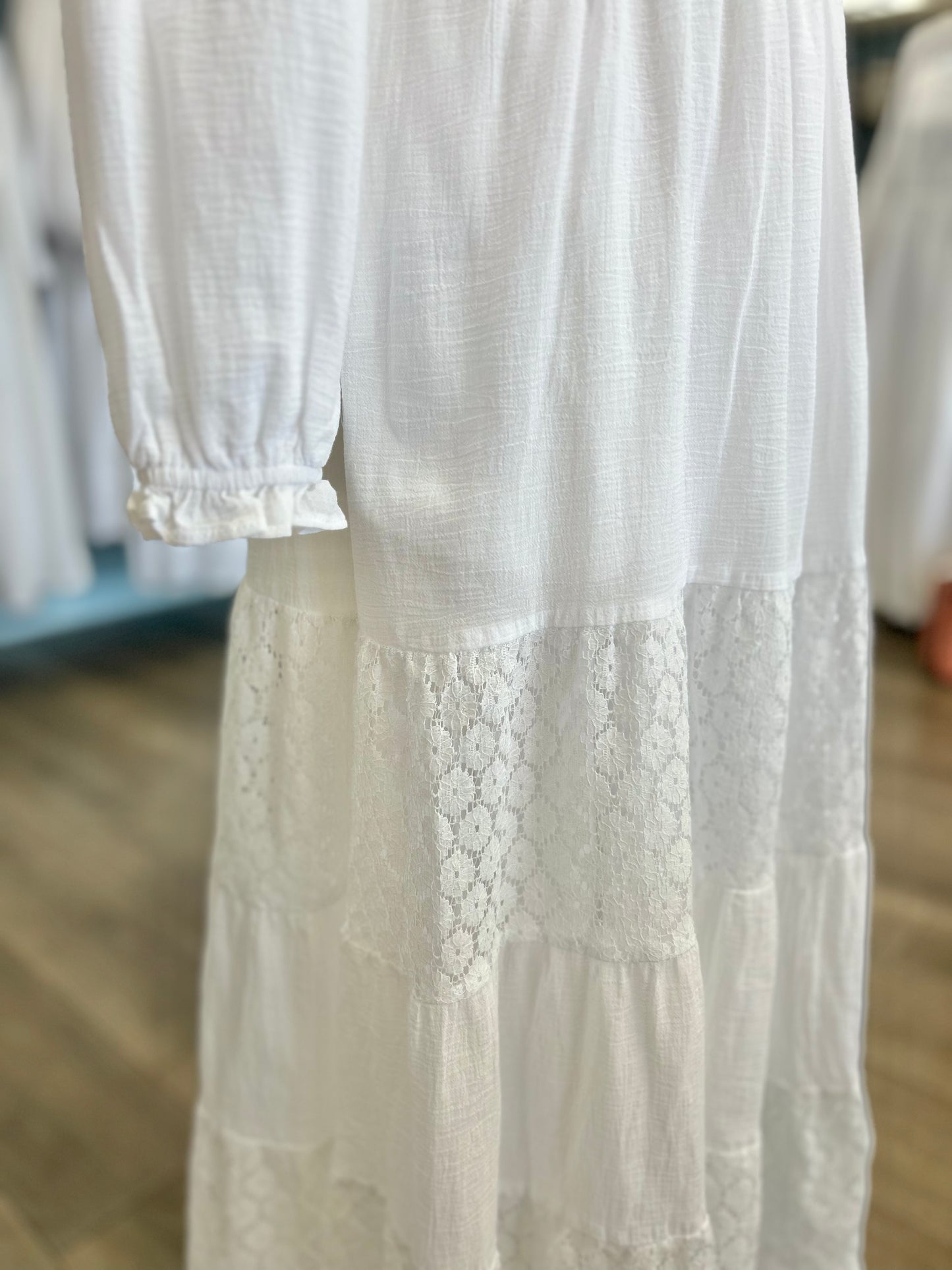 White dress with tiered lace panel skirt and frilly cuffs. 