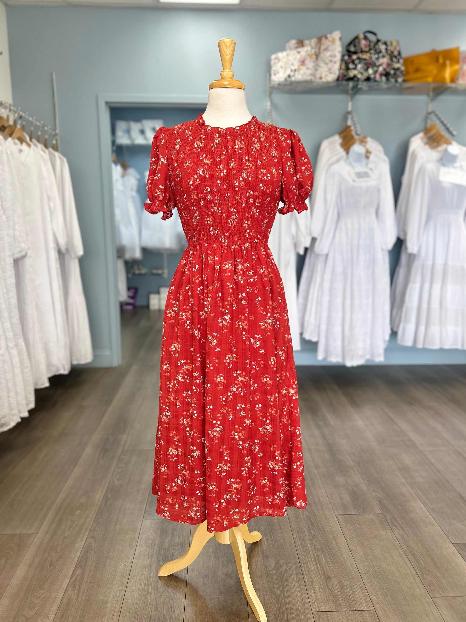 Red midi dress with floral pattern and smocked bodice.