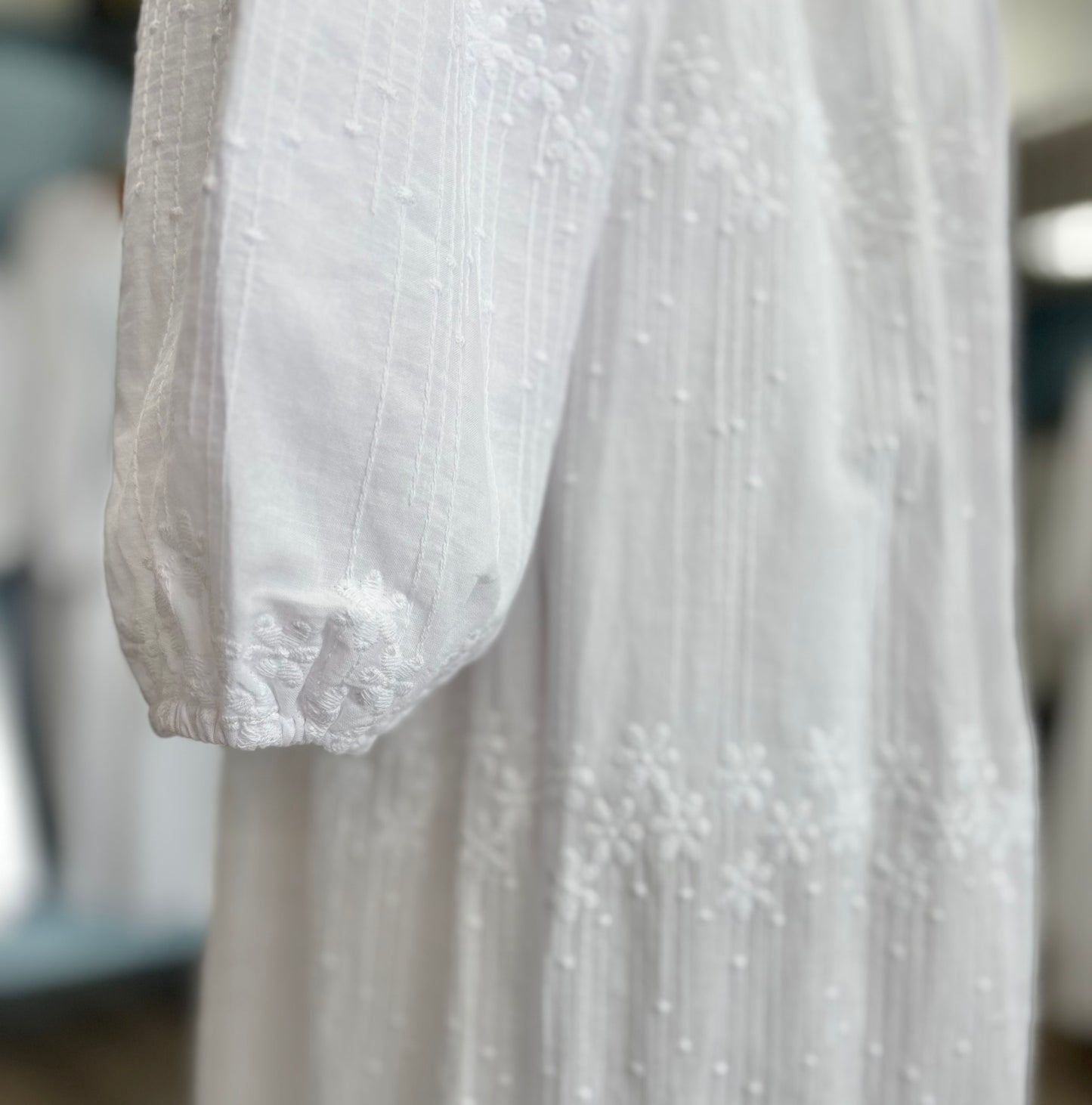 Bishop sleeve cuff of white dress. 