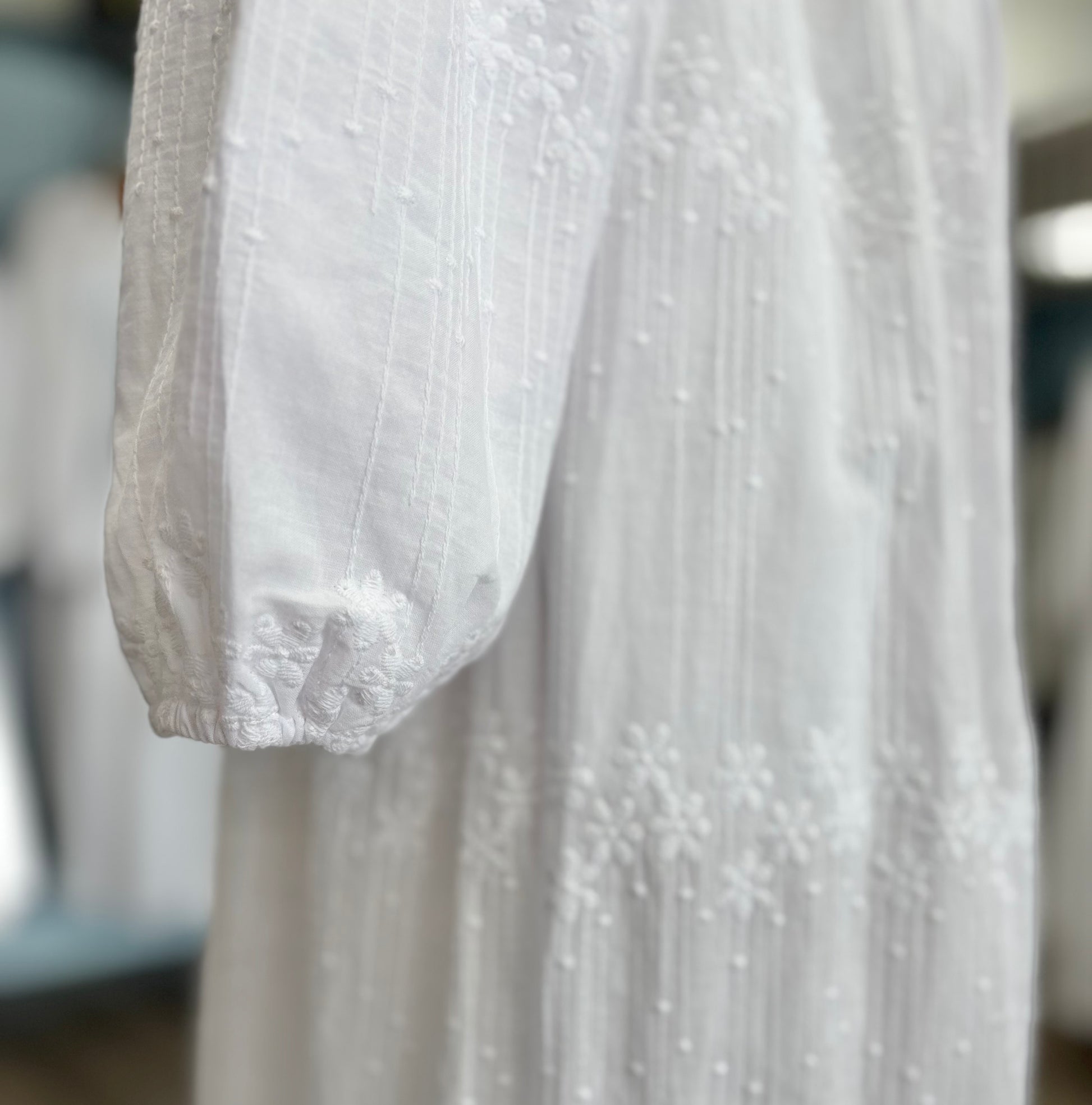 Bishop sleeve cuff of white dress. 