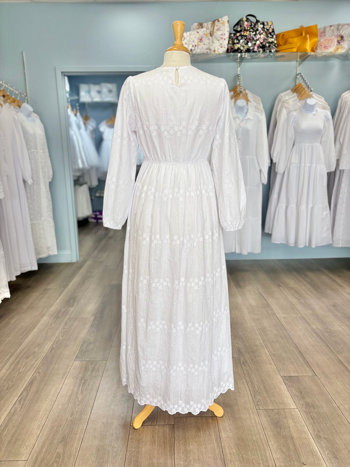 Back of long white cotton dress on mannequin. 