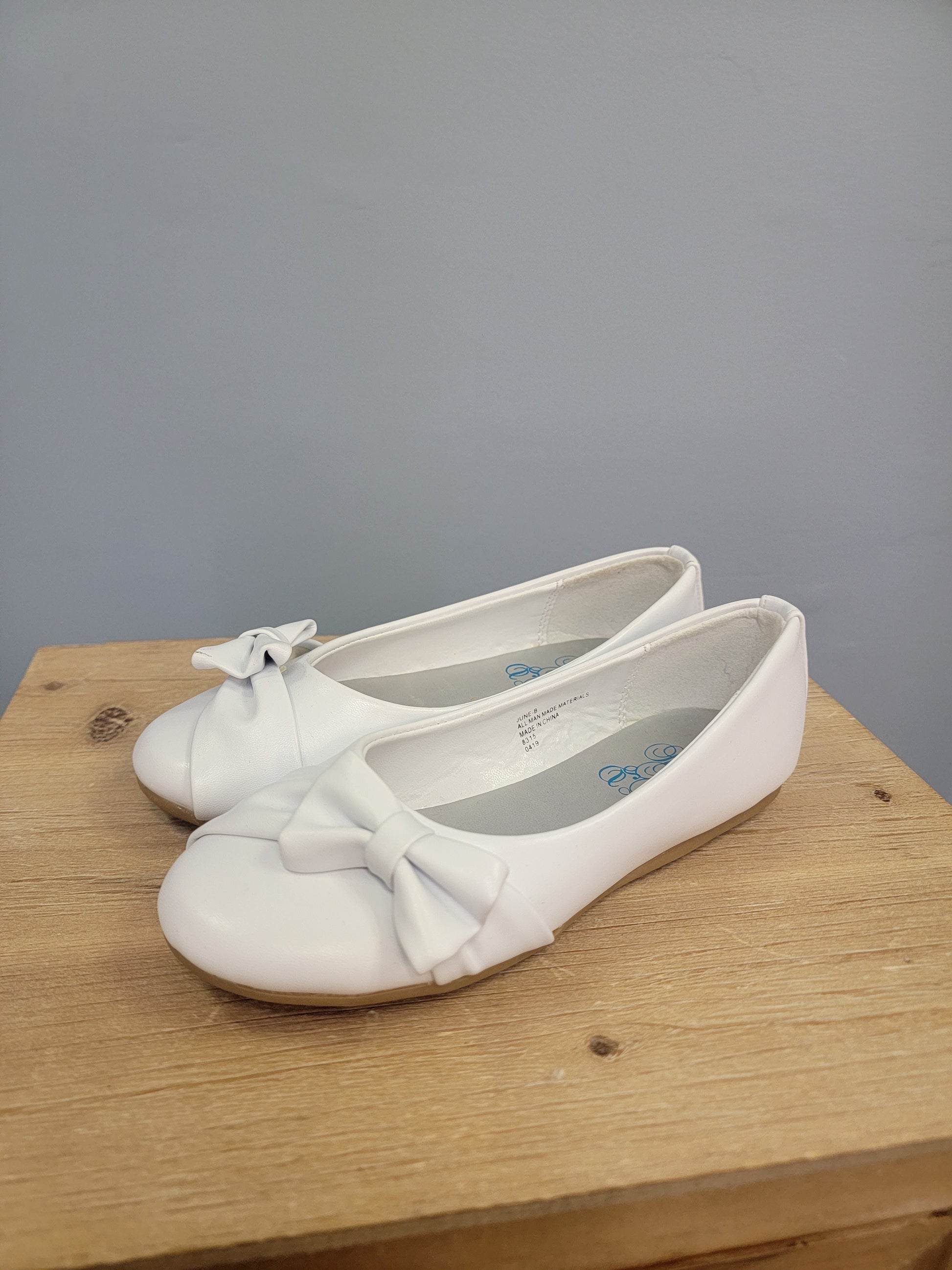 white flat shoe for girls with bow on the toe