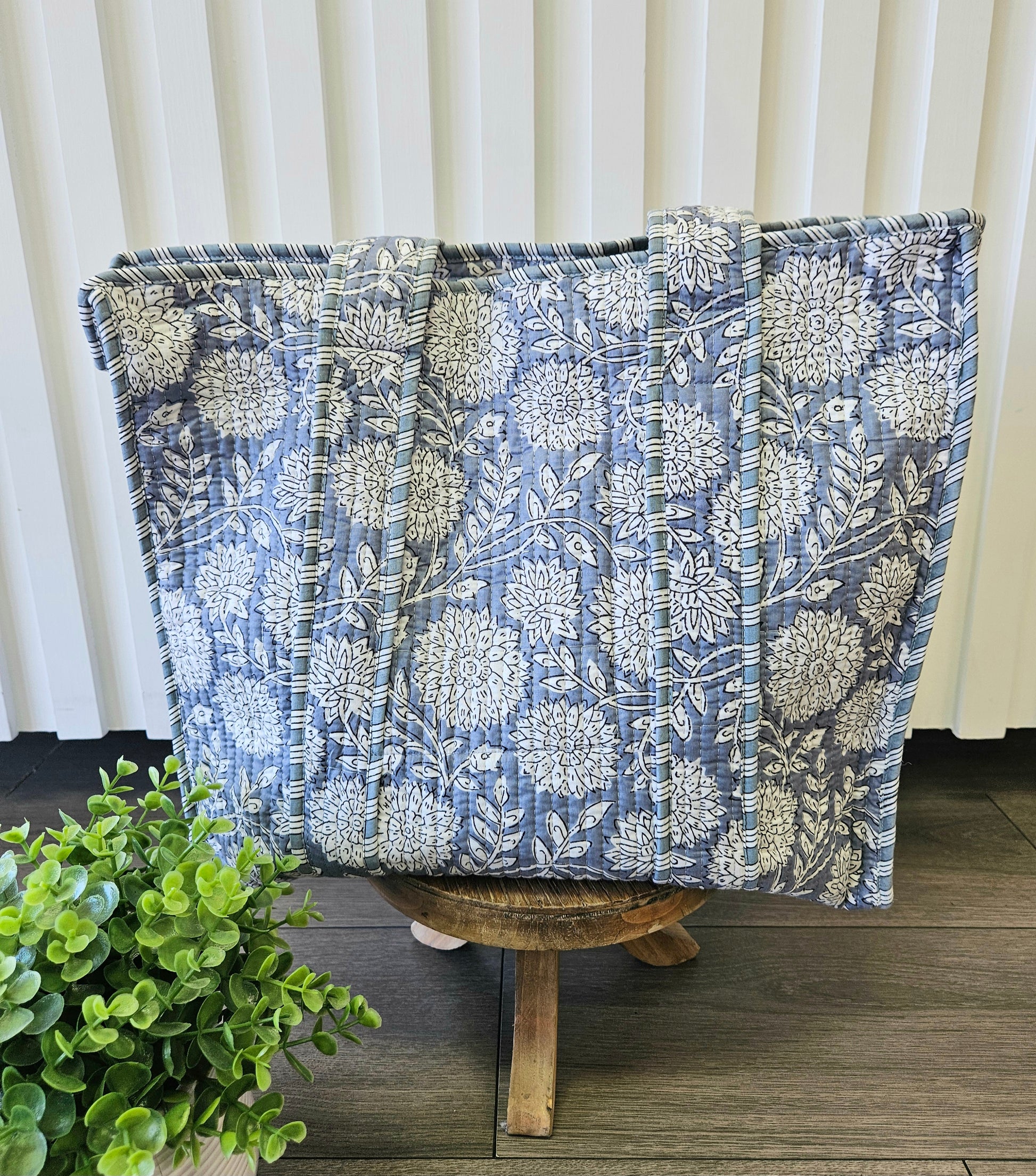 blue floral quilted bag on stool