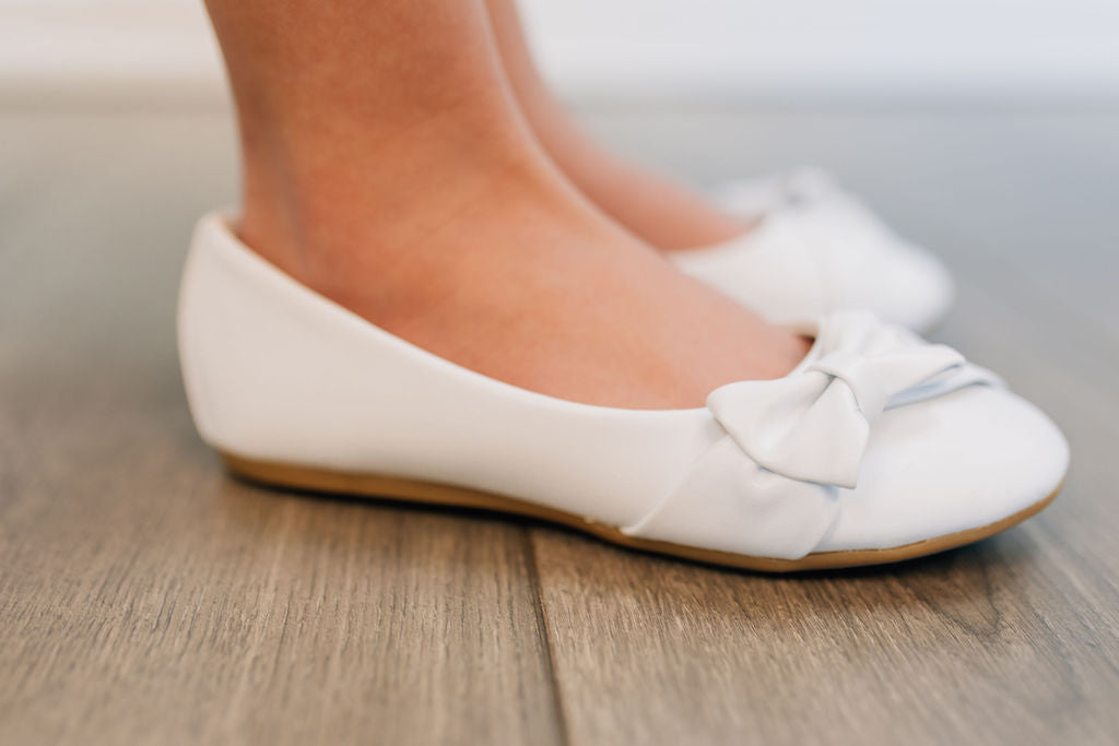 white flat shoe for girls with bow on the toe
