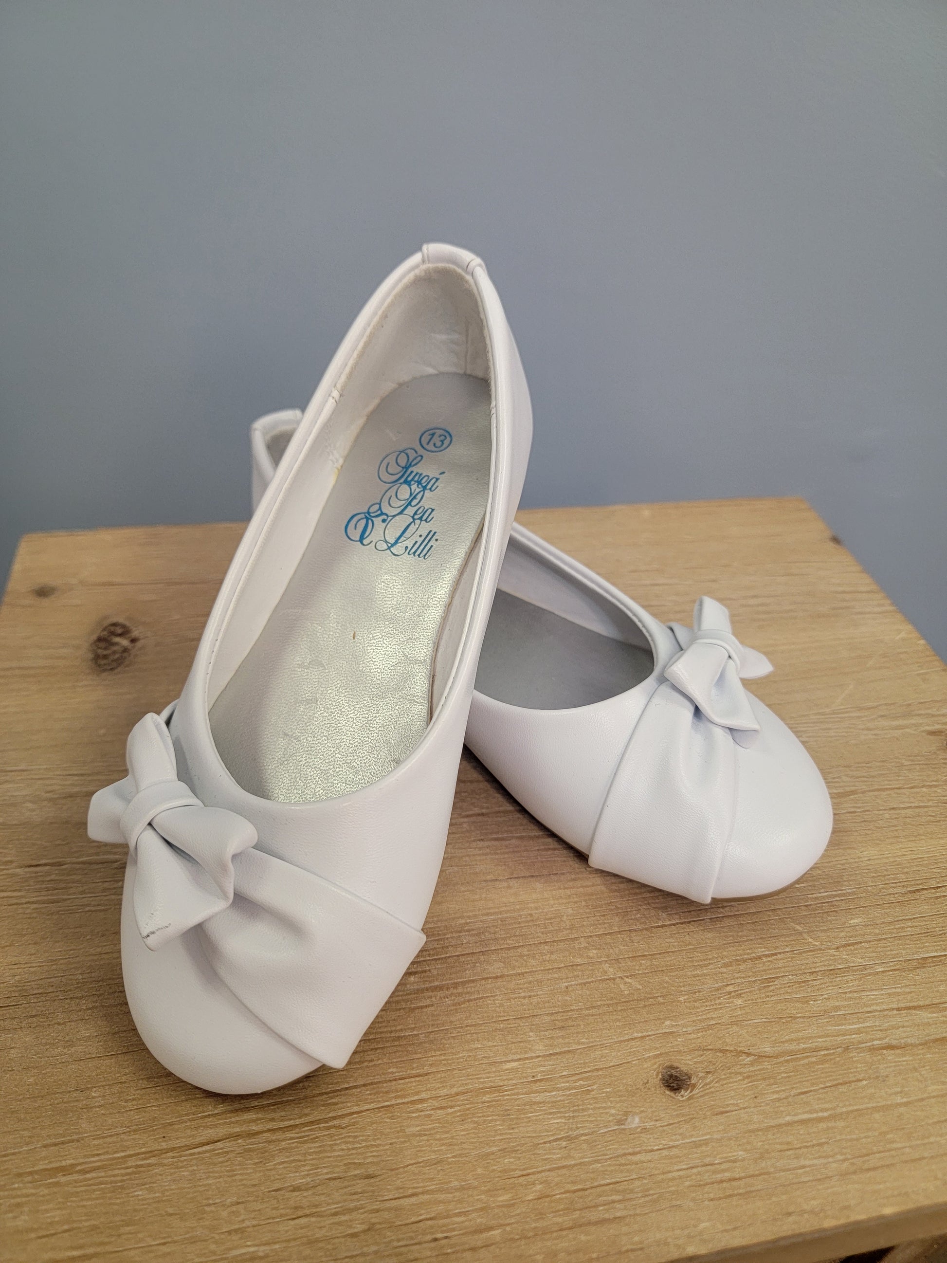 white flat shoe for girls with bow on the toe