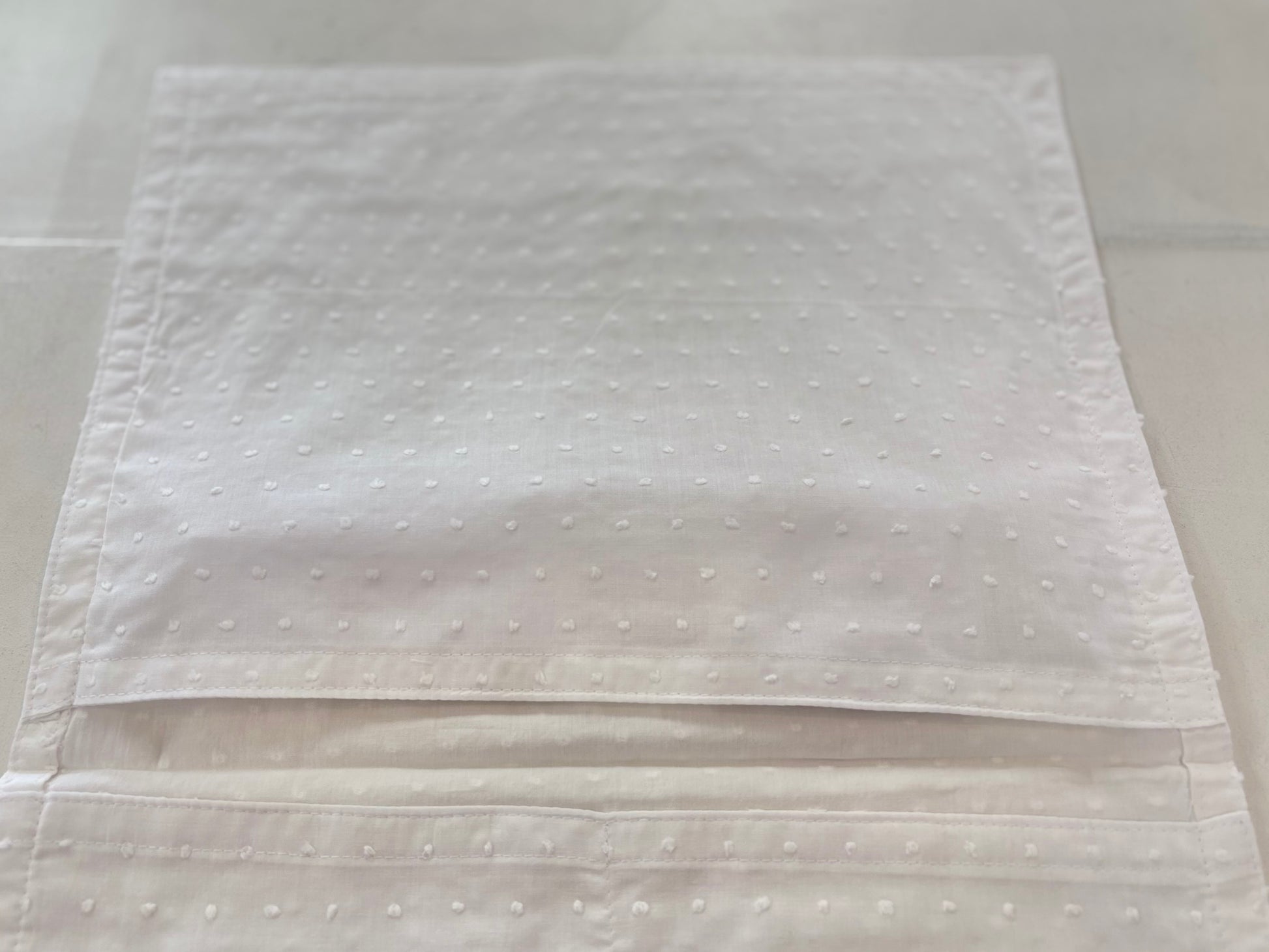 Open cotton envelope with pockets inside.