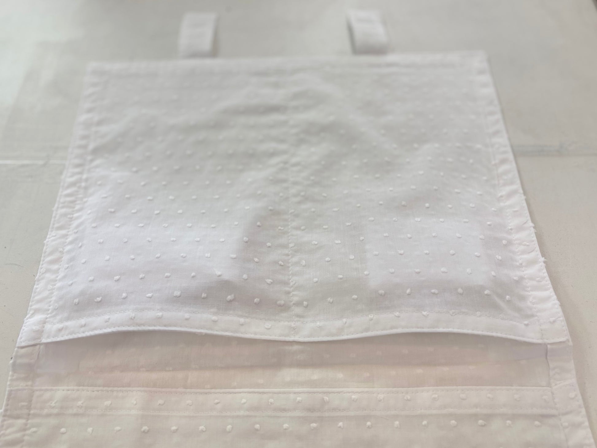 Open cotton envelope with pockets inside.