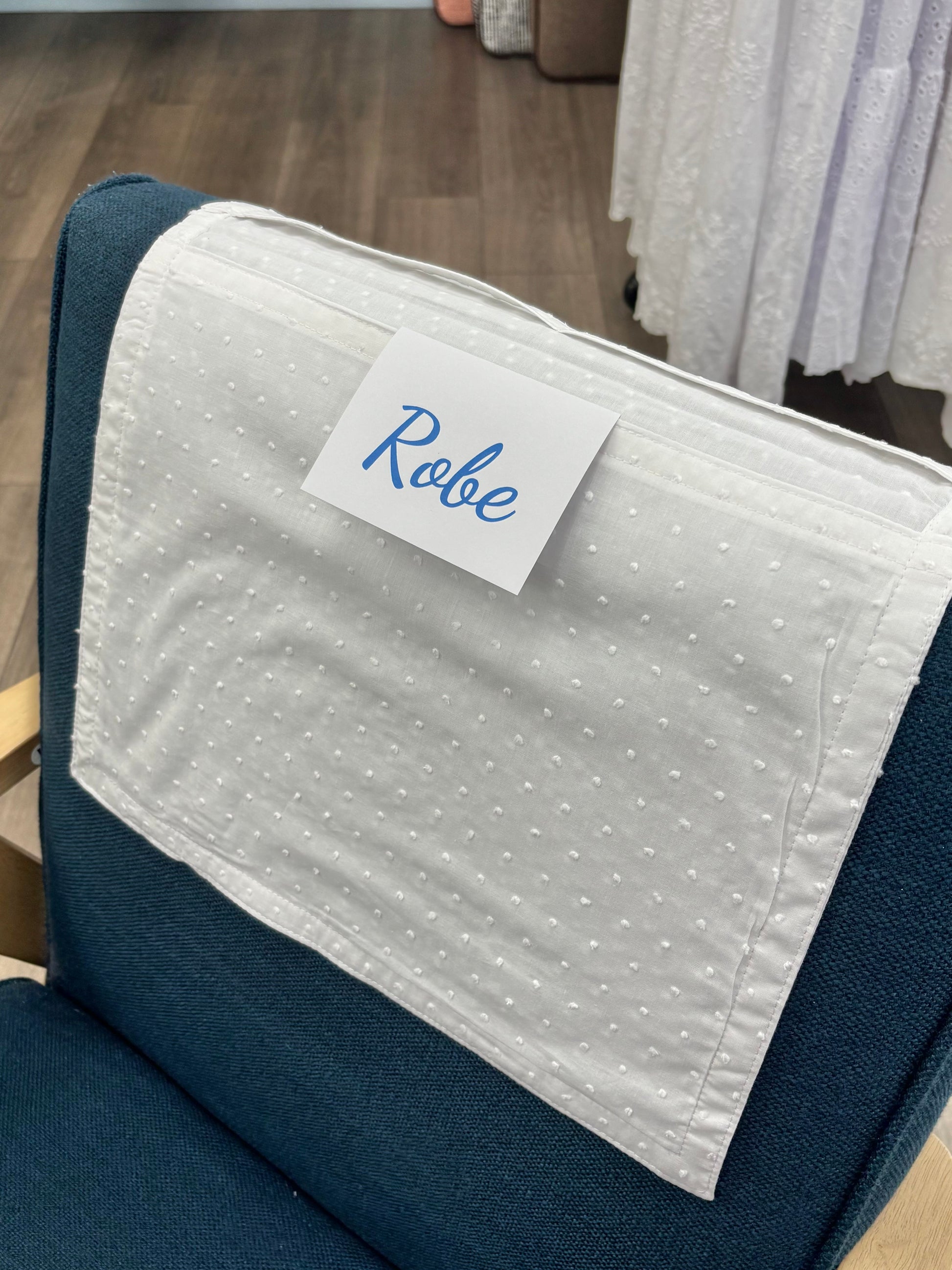 Cotton envelope draped over chair with labels.